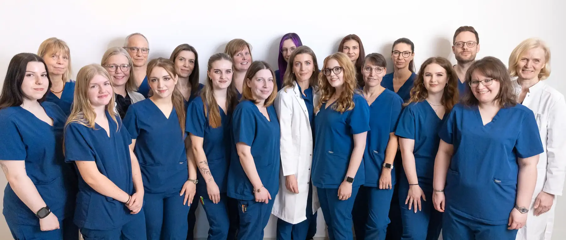 Gruppenfoto des Praxisteams vor weißem Hintergrund